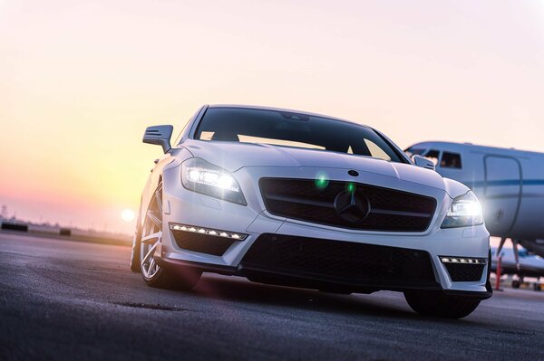 White Mercedes Benz at sunset at the airport