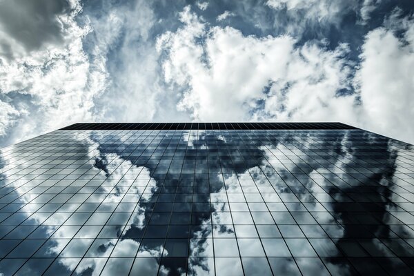 Reflejo de nubes en un edificio de vidrio alto