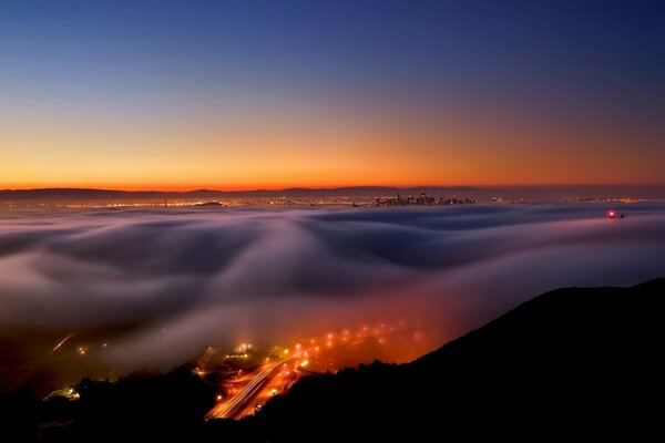 Paisaje de niebla en la noche sobre la ciudad