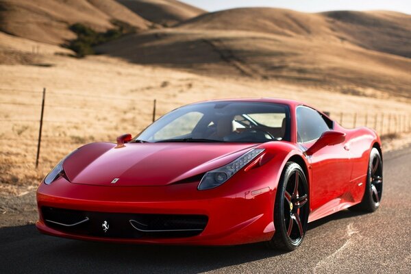 Ferrari rojo conduce por una carretera desierta