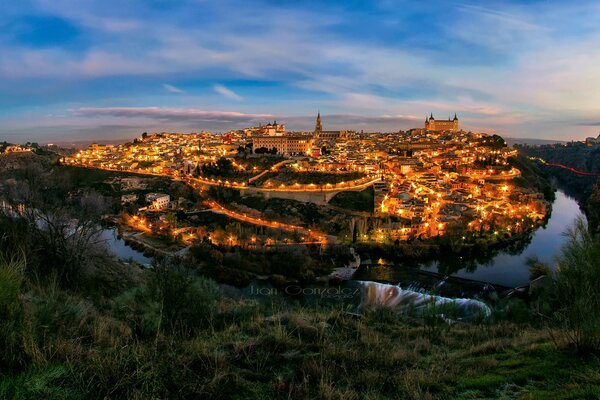 Ciudad de la tarde, brillando con luces en el anillo del río y verde Esmeralda