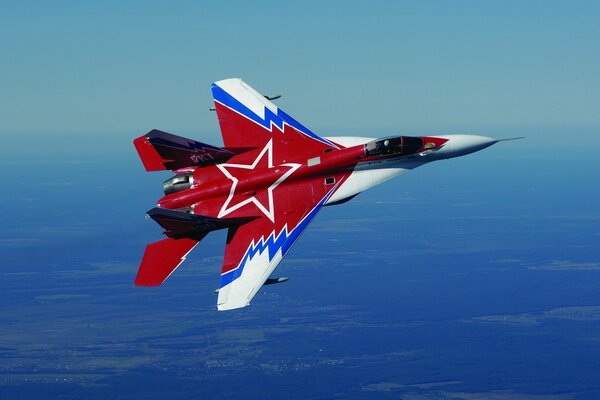 A Russian fighter jet is flying through the sky above the ground