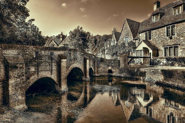 Castillo tratado en Inglaterra a través de un puente que pasa por un río