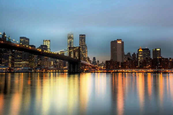 Vista nocturna de los rascacielos de nueva York y el puente de Brooklyn