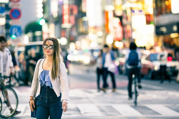 Street traffic, pedestrian crossing girl in sunglasses, cyclists