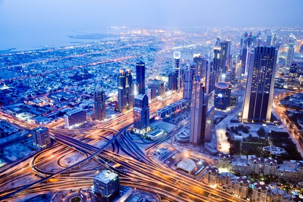 Night city in Dubai panorama of buildings and roads