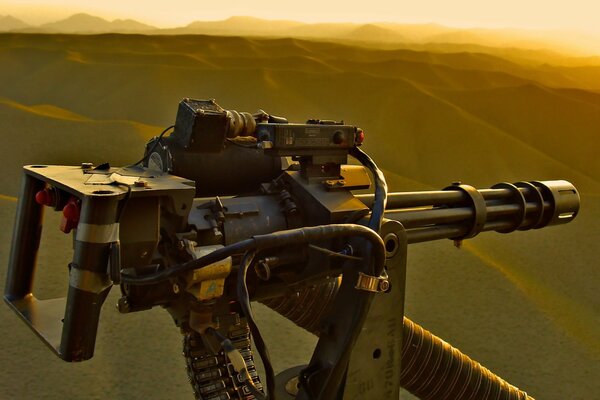 Un hélicoptère avec une mitrailleuse m134 vole dans le désert