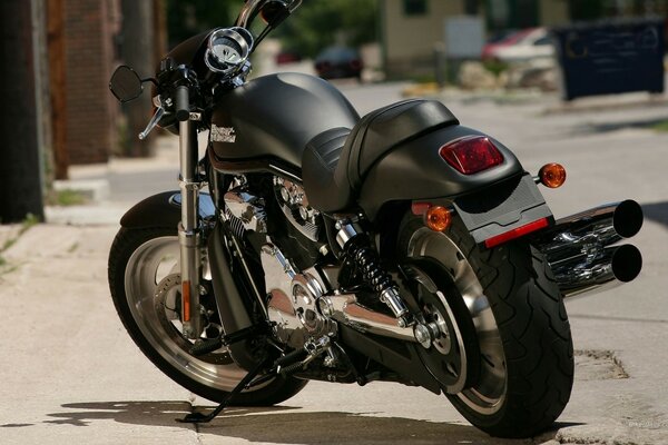 Standing on the running board is a modern Harley Davidson black motorcycle