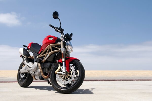 La moto ducati se tient sur le sable dans le désert