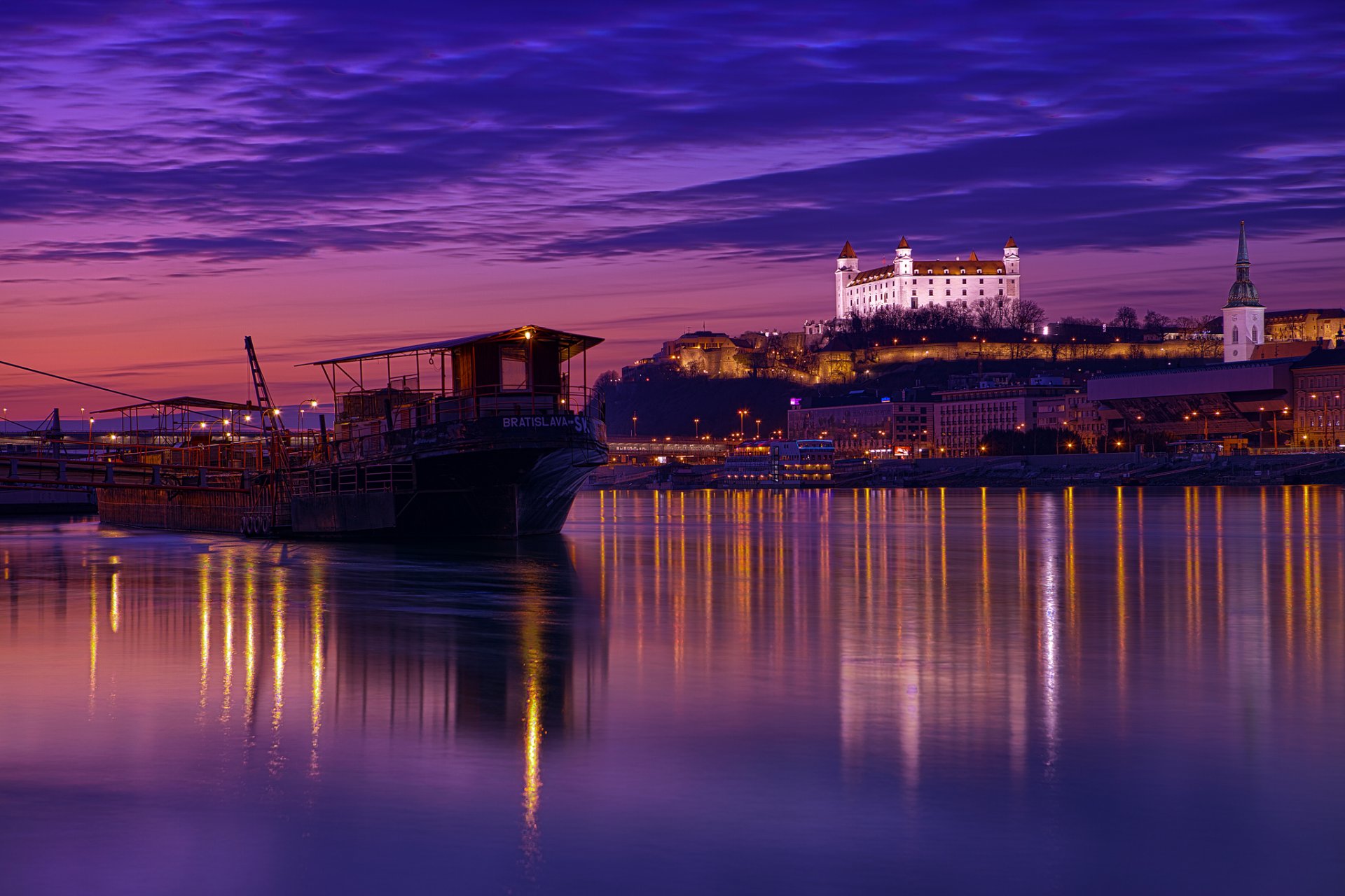 eslovaquia bratislava ciudad capital noche arquitectura iluminación luces río danubio lila púrpura cielo nubes reflexión