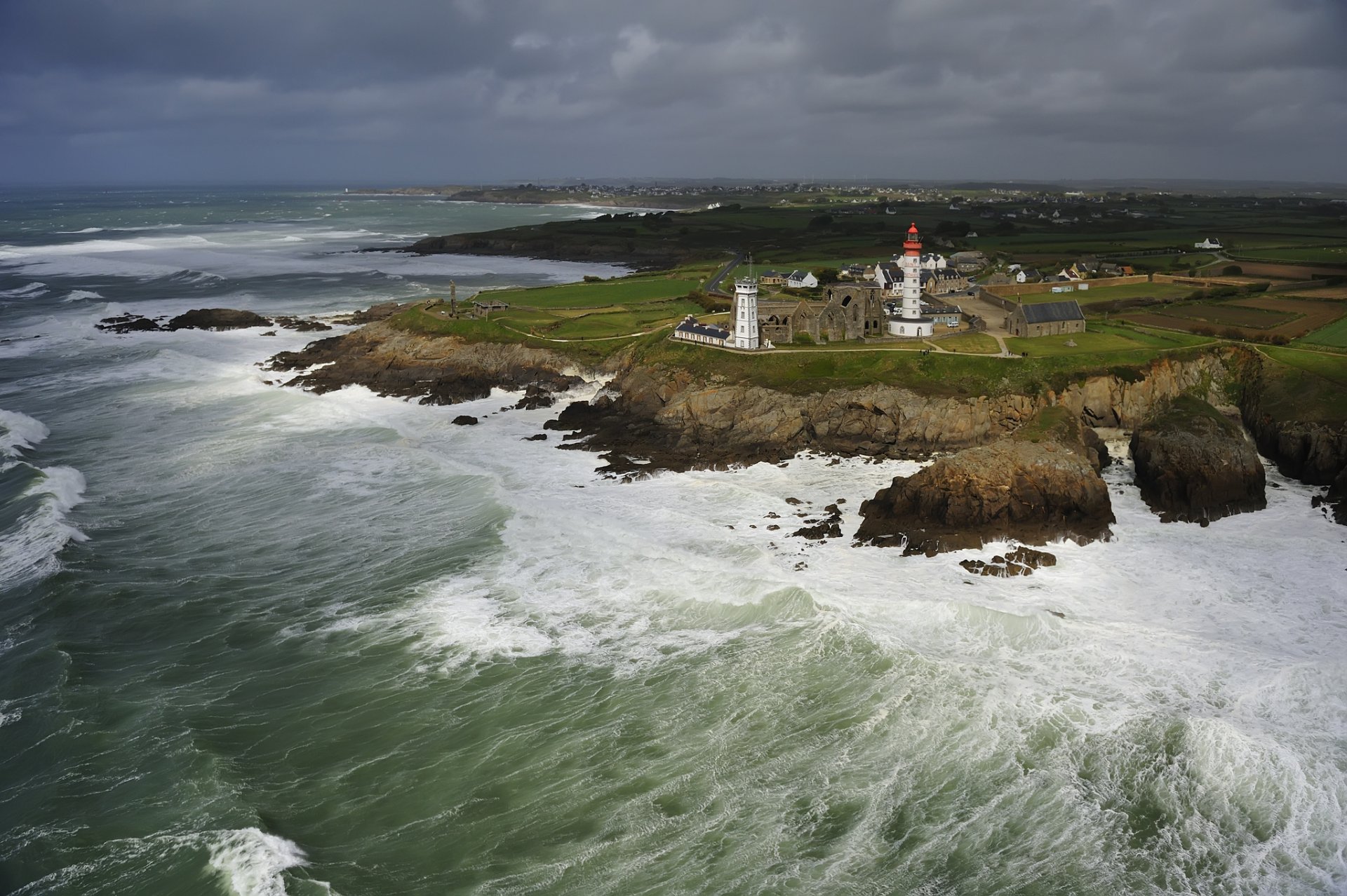 ville phare roches vagues ciel nuages