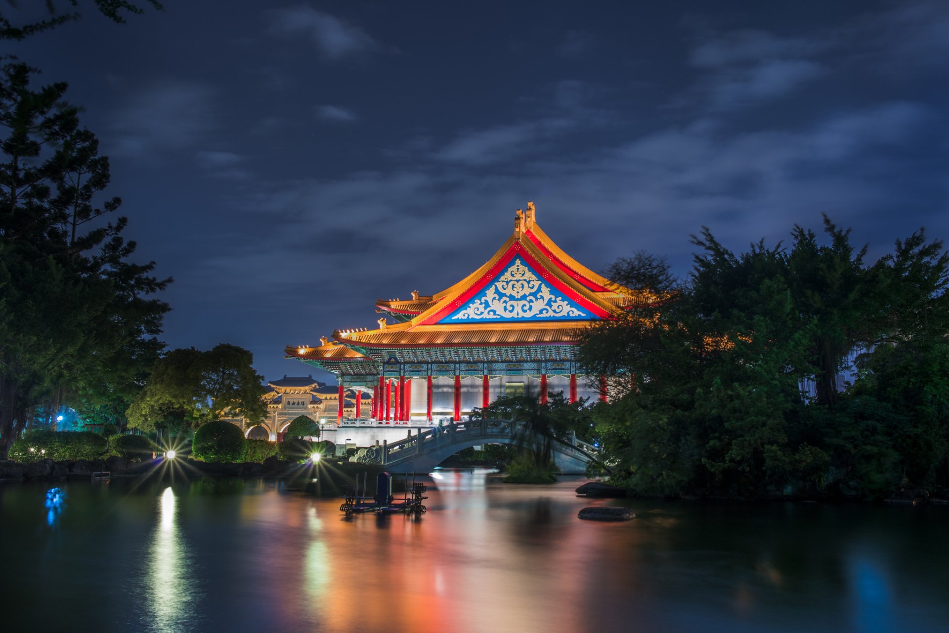 taiwán taipei teatro nacional edificio arquitectura jardín árboles puente estanque noche iluminación azul cielo nubes