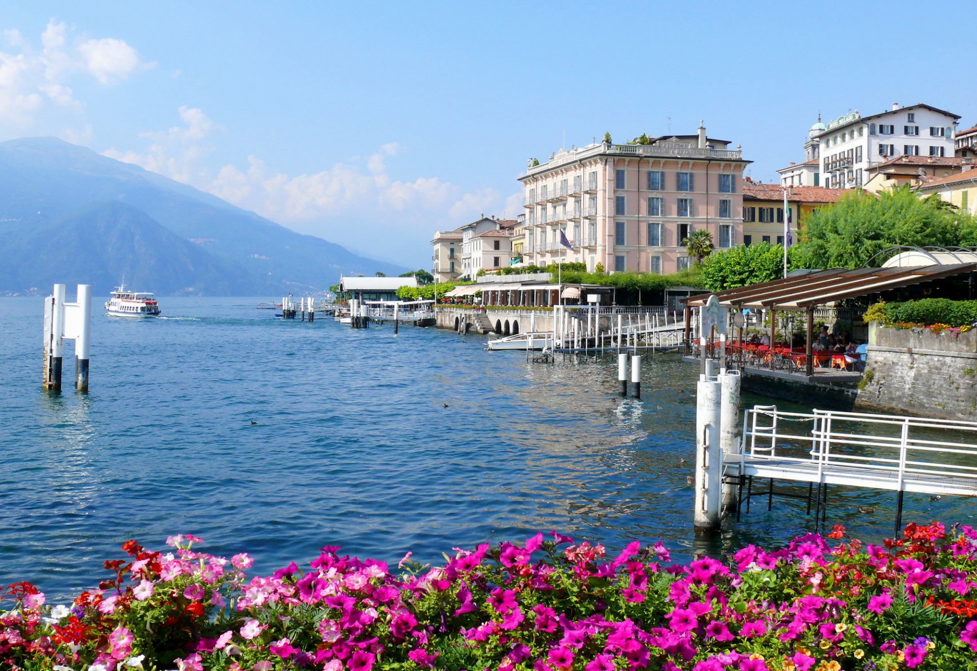 italia lombardía bellagio ciudad casas montañas lago de como flores barco foto