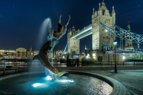 Beautiful fountain with lights on the background of Tower Bridge