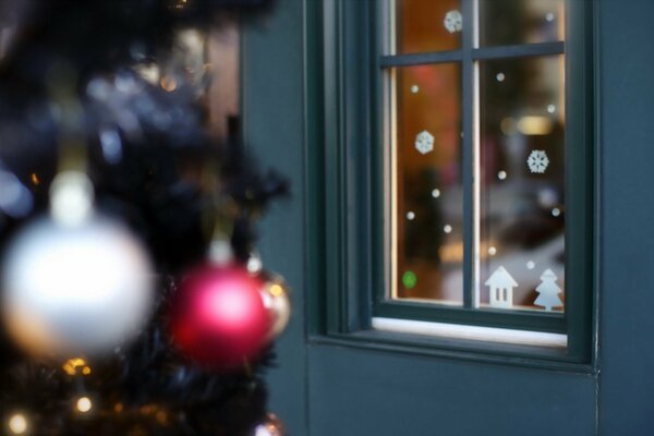 Juguetes de Navidad en el árbol cerca de la casa