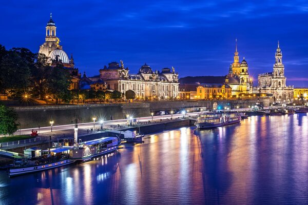 The architecture of the city on the riverbank in bright colors of lights