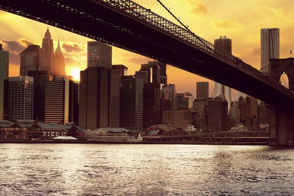 Brooklyn Bridge in New York. The sun is at sunset
