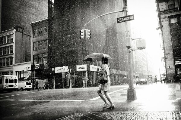 Foto en blanco y negro de una chica bajo la lluvia