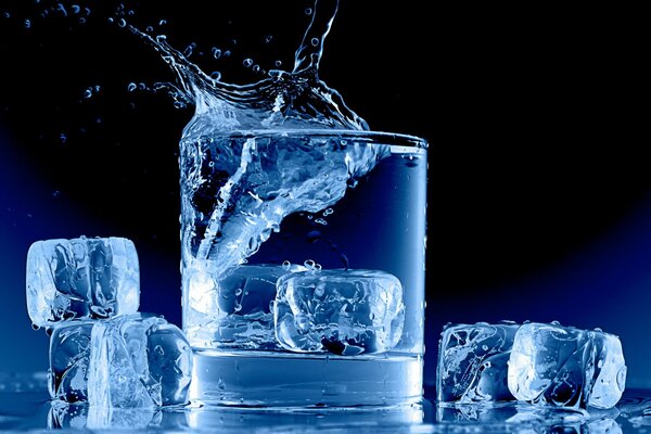 Un vaso de agua con cubitos de hielo flotando hacia arriba