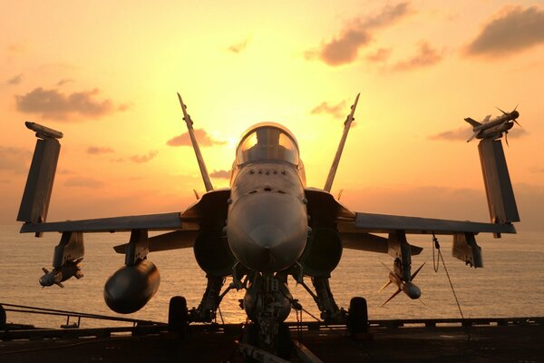 McDonnell Douglas fa-18 en medio del mar y la puesta del sol