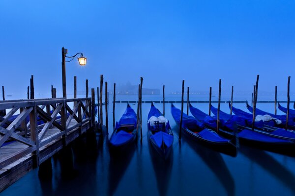 Venecia en la niebla de la góndola bajo la linterna