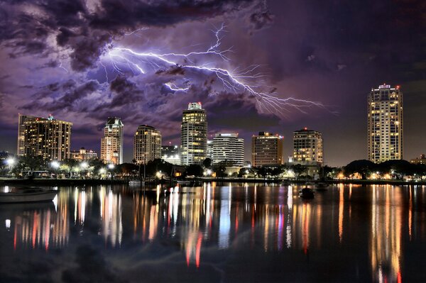 Ciudad al lado del río. Cielo nocturno con tormenta