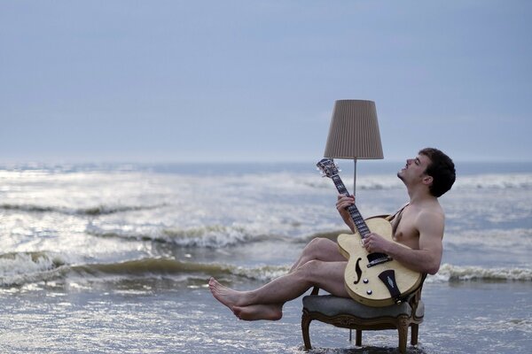 A man with a guitar on the seashore