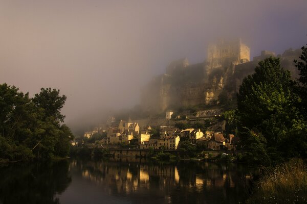 Castillo medieval a orillas del río por la noche