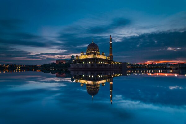 Malaysia like a mosque in the distance glows in the water reflection