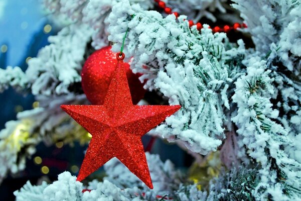 A red star on a snow-covered Christmas tree