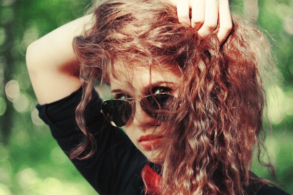 Curly red-haired girl with glasses