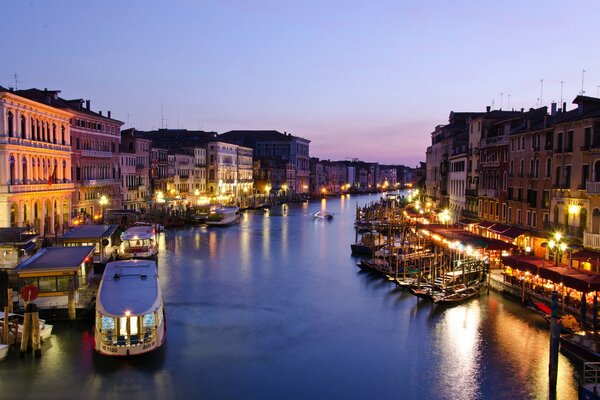Grand canal avec des bateaux à Venise du soir