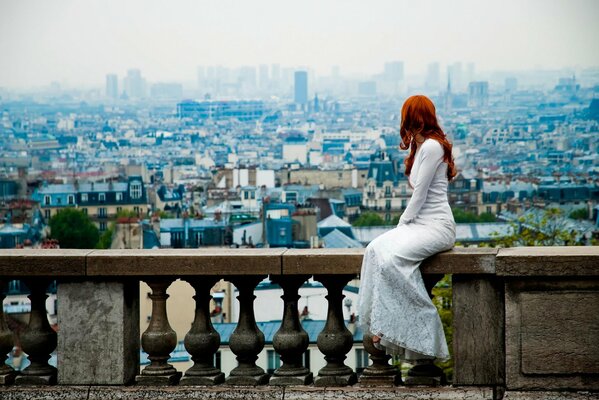 Das Mädchen ist in der Stadt. Rothaarige Mädchen im Kleid. Blick auf Paris