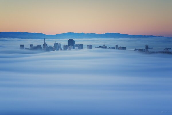 Les sommets des bâtiments qui sortent du brouillard