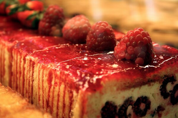 Der Kuchen mit rotem Sirup ist mit frischen Himbeeren verziert