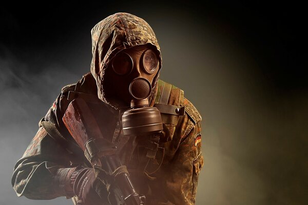 A soldier in a gas mask holds a weapon