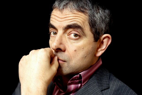 Rowan Atkinson tiene la mano vicino alla bocca