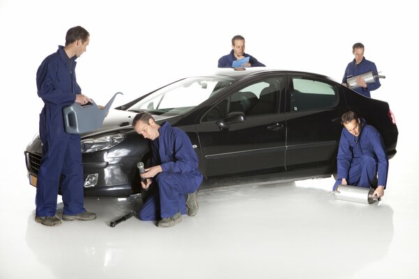 The team is servicing the car on a white background