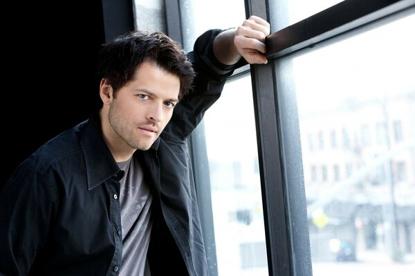 Aktor Misha Collins przy oknie