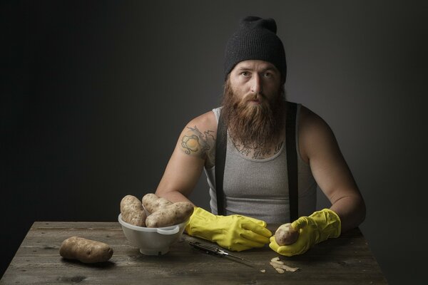 L hipster domestico sbuccia le patate in buona qualità