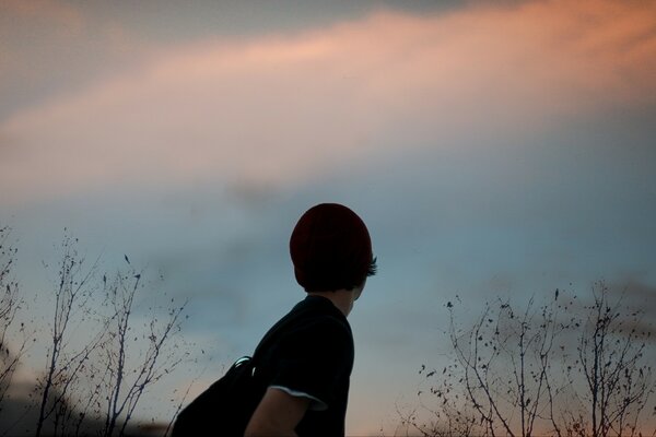 Ragazzo con cappello invernale guardando il cielo