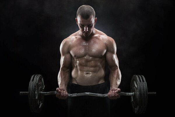 The bodybuilder looks at the barbell with sadness