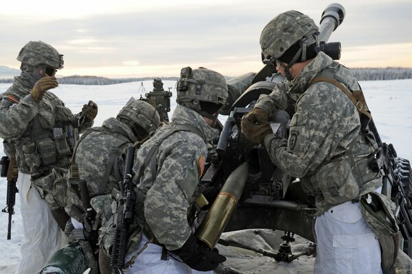 Gunners shoot from a large 105mm cannon