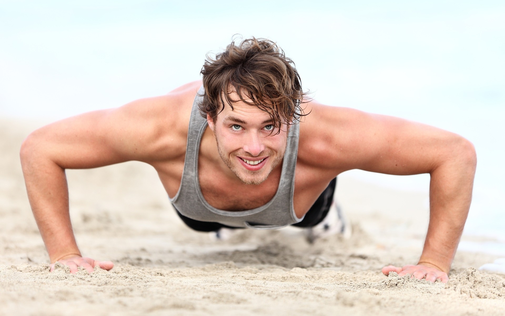 plage homme muscle sable