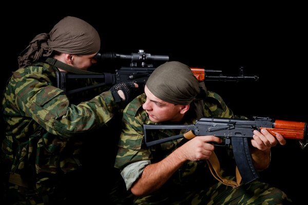 Soldiers with machine guns on a black background