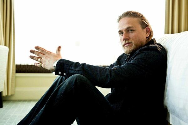 Actor Charlie Hunnam is sitting on the floor