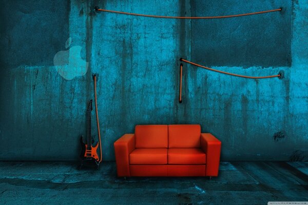 On a blue background, a red sofa, a guitar and an apple