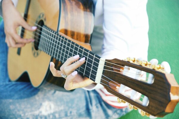 A girl playing music on a guitar