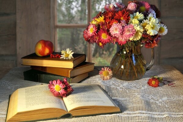 Books on the table with a vase of flowers