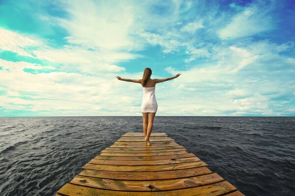 The girl on the pier is enjoying a vacation